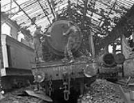 Personnel of No.1 Railway Workshop Company, Royal Canadian Engineers (R.C.E.), preparing to repair damaged locomotives, Vaucelles, France, 23 July 1944 23-Jul-44