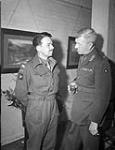 Lieutenant G.P. Comper (left), a paratroop officer who fought at Arnhem, talking with Major-General E.G. Weeks at the first annual reunion of CANLOAN officers, Royal Empire Society, London, England, 14 April 1945 April 14, 1945