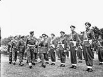 General H.D.G. Crerar, General Officer Commanding 1st Canadian Army, and Captain C.B. Newman, Assistant Provost Marshal, 4th Canadian Armoured Division, inspecting a company of the Canadian Provost Corps, Apeldoorn, Netherlands, 12 July 1945 12-Jul-45