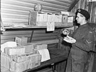 Lance-Corporal E.J. Priess of the Essex Regiment sorting the unit's mail, England, 27 January 1944 January 27, 1944