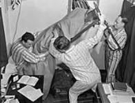 Students at the Khaki University of Canada rousing student R.C. Rutherford from bed in time for classes, Leavesden, England, 15 April 1946 April 15, 1946