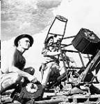 Privates Roger Widdifield (left), West Nova Scotia Regiment, and Everett Dewar, Saskatoon Light Infantry (M.G.) attached to the West Nova Scotia Regiment, manning an Oerlikon 20mm. anti-aircraft gun, Spinazzola, Italy, 1 October 1943 October 1, 1943.