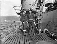Members of a boarding party from H.M.C.S. MATANE which accepted the surrender of a German submarine depot ship off the coast of Norway, seen aboard a surrendered German submarine, Loch Eriboll, Scotland, May 1945 May, 1945.