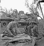Private W.A. Lloyd repairs a tarpaulin while Lance-Corporal W.L. Milburn mends rope, 1st Infantry Brigade Workshop, Royal Canadian Electrical and Mechanical Engineers (R.C.E.M.E.), San Leonardo di Ortona, Italy, 13 December 1943 December 13, 1943.