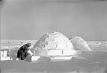 Inuk building an igloo 1948-1953.