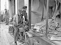 Infantrymen of the South Saskatchewan Regiment locating German anti-tank projectiles in a store window, Oldenburg, Germany, 3 May 1945 May 3, 1945