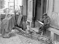 Sergeant H. Lester, Support Company, South Saskatchewan Regiment, reading the Maple Leaf newspaper, Oldenburg, Germany, 3 May 1945 May 3, 1945