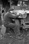 Unidentified soldier stencilling numbers on the hood of a jeep, England, 21 December 1943 December 21, 1943.