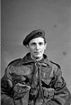 An unidentified non-commissioned officer of the 1st Canadian Parachute Battalion, who is wearing his maroon beret, plastic cap badge, Dennison smock and webbing, London, England, 1943 1943