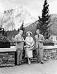 Their Majesties, King George VI, and Queen Elizabeth with the Right Honourable W. L. Mackenzie King, Prime Minister of Canada, chatting on terrace, adjoining Banff Springs Hotel. 27 May 1939.