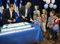 [Prime Minister Stephen Harper and Denis Lebel hand out pieces of cake to children on the occasion of Saint-Jean-Baptiste Day, the Fête nationale du Quebec, in Dolbeau-Mistassini, Quebec] 23 June 2013