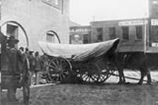 Covered wagon at market ca. 1900