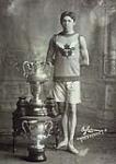 Tom Longboat, Canadian runner, standing beside trophies    22 avri1 1907.