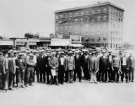 Group of unidentified men standing in the street of an unidentified town during the Depression ca. 1929 - 1936.