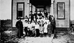 Teachers and schoolchildren in front of schoolhouse, Narcisse Colony. Bender, Manitoba 1921