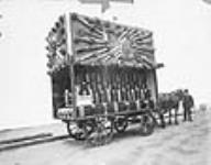 Advertising for immigration to Canada: a wagon being pulled by horses, heavily laden with agricultural produce, such as corn, grain, cereal and vegetables 1905