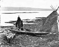 An Inuit man getting ready for a Seal Hunt, his Toupek or skin tent on the right 1872-1873.