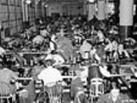 Workers in sewing room put together uniforms for Canadian army Dec. 1939