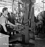 Workman taps fuses using machine Aug. 1940