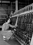 A woman worker stacks Bren gun plants in rows at the John Inglis Co. Bren gun plant 8 avri1 1941
