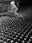 Un ouvrier examine une bombe à l'usine de fabrication de bombes Cherrier May 1941