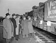 Des responsables veillent sur des chars d'assaut Valentine de l'armée canadienne produits par les ateliers Angus, sur des wagons de chemin de fer, prêts à êtreexpédiés en Russie 9 déc. 1941