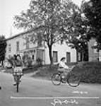 Des ouvrières des munitions de l'usine Dominion Arsenals Ltd. à Québec, retournent chez elles, à Sainte-Foy, à bicyclette ca. août 1942