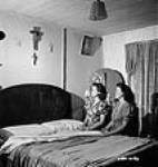 Celine and Roberte Perry, two employees of the Dominion Arsenals plant, pray at their bedside before going to bed 24 Aug. 1942