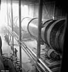 View of length of large long kiln used to dry out alumina oxide to alumina at the Arvida plant of the Aluminum Company of Canada janv. 1943