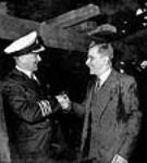 Captain P.D. Townsend, skipper of the S.S. Fort Albany shakes the hand of Hector Duchesneau, foreman smith with Davies since 1886 at the launch ceremony of the S.S. Fort Albany May 1943