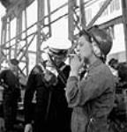 Mme Joyce Jones, passeuse de rivets au chantier naval, et Len Christianson, de la Marine royale du Canada, fument une cigarette lors d'une pause June 1943
