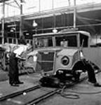À l'usine General Motors d'Oshawa, des ouvriers assemblent un véhicule militaire ca. 1942