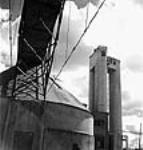 View of a sulphur storage tank, Jenson tower and conveyor taking sulphur to the digester building at the International Pulp and Paper Company sept. 1943
