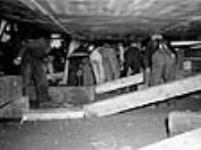 Workmen working underneath a 10,000-ton cargo vessel in a shipyard Sept. 1943
