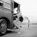 Mme Jack Wright monte dans un autobus pour aller travailler dans une fabrique de munitions Sept. 1943