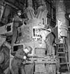 Workmen assemble a coal pulverizing mill in the Polymer Rubber Corporation plant oct. 1943