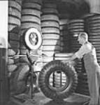 À l'usine Société Polymer Limitée, l'ouvrier T.G. Hillman pèse des pneus oct. 1943