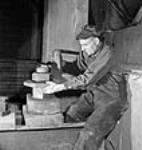 À la société Société Polymer Limitée, un ouvrier règle un boulon de 4 pouces auquel est suspendue une chaudière de 190 000 livres Oct. 1943