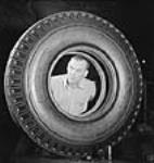 Workman John Seliger makes the final inspection of a new synthetic rubber tire at the Dominion Rubber plant Oct. 1943
