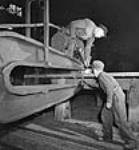 Des ouvriers travaillent sur des pièces d'une locomotive X-Dominion pour expédition en Inde Nov. 1943