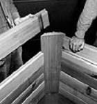 Workmen demonstrate the Loxtave (lock-stave) principle of prefabricated housing, using tongue and groove joints to hold walls tight June 1944