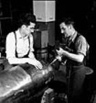 Les ouvriers Frank O'Neill et Charlie Donnelly percent le nez d'une tête de torpille à l'usine John Inglis Co mai 1944