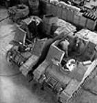 À l'usine Montreal Locomotive Works, des ouvriers effectuent les dernières touches de finition sur des obusiers automoteurs presque entièrement assemblés Summer 1943