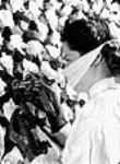 Une employée injecte des spores de pénicilline vaporisées par jet d'air stérilisé dans un bouillon de surface contenu dans des bouteilles aux laboratoires Merck May 1944