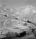 Vue d'un semi-chenilles de 10 tonnes transportant du minerai d'amiante sur la pente de la mine à ciel ouvert de la société Les mines d'amiante Bell Limitée à Thetford Mines June 1944