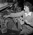 Female worker Noella Barry assembling panel parts of a radio set in the RCA Victor plant July 1944