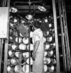 Workman Arthur Braise dries cabinet parts using infrared lights at the RCA Victor plant juil. 1944