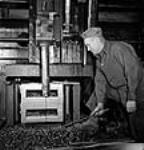 Un ouvrier racle le métal excédentaire produit lors de l'usinage des pièces de locomotive « X-Dominion » Nov. 1943