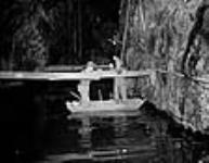 Malagash salt mine miners working on some stays in a boat floating on an underground brine lake mars 1944