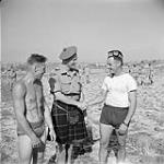 [Three soldiers - two are shaking hands and one is wearing a kilt] n.d.